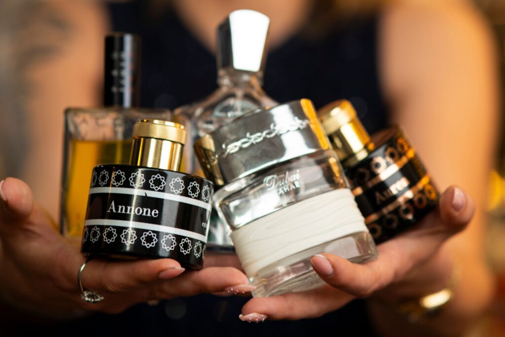 come conservare i profumi per evitarne il deterioramente flaconi in mano a donna nero bianco