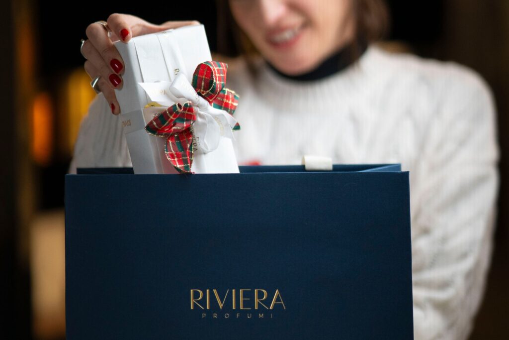 Mamma e Profumi | I Migliori Regali per la Festa della Mamma donna busta di lusso profumo in mano