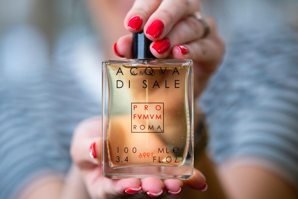 flacone acqua di sale profumum roma in mani smalto rosso profumo estate