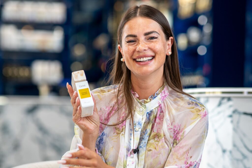 donna sorridente bella con camicia tiene profumo gritti venetia dorato Quali sono i profumi da donna più venduti? Ecco 5 bestseller della profumeria di nicchia per la donna moderna da non perdere.