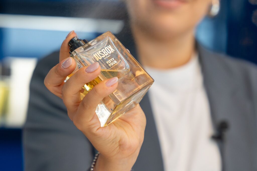 donna con profumo, profumo jusbox, mano con flacone profumo, profumi equivalenti, cosa sono profumi equivalenti, profumi tester, profumi economici