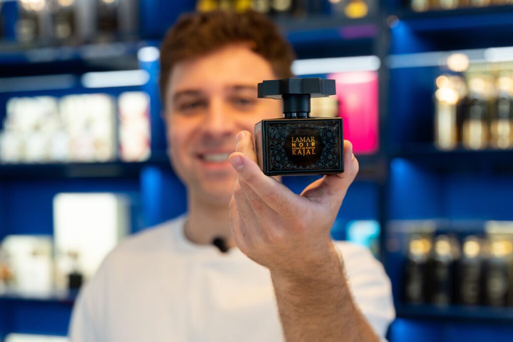 profumi uomo più venduti, uomo profumeria, flacone nero, uomo tiene flacone profumo, profumi da uomo, per uomo, bestsellers