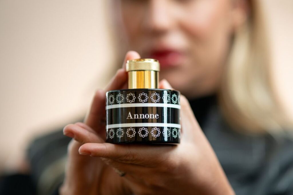 profumo annone, flacone nero, annone pantheon, pantheon roma profumi, profumo pantheon, donna tiene profumo, mani, flacone profumo