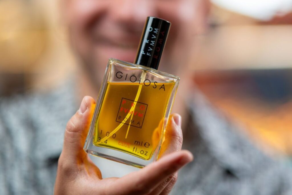 flacone profumo gioiosa profumum roma, profumum roma, profumo gioiosa, profumi alla vaniglia da donna, mano tiene profumo