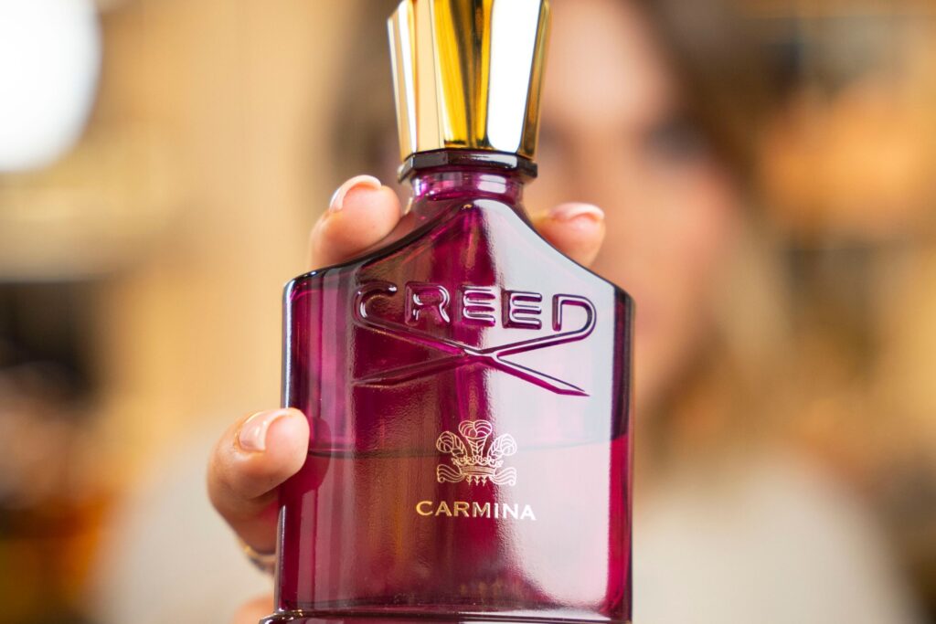 profumo carmina creed, profumo creed, creed, carmina, flacone rosa, mano, profumo,